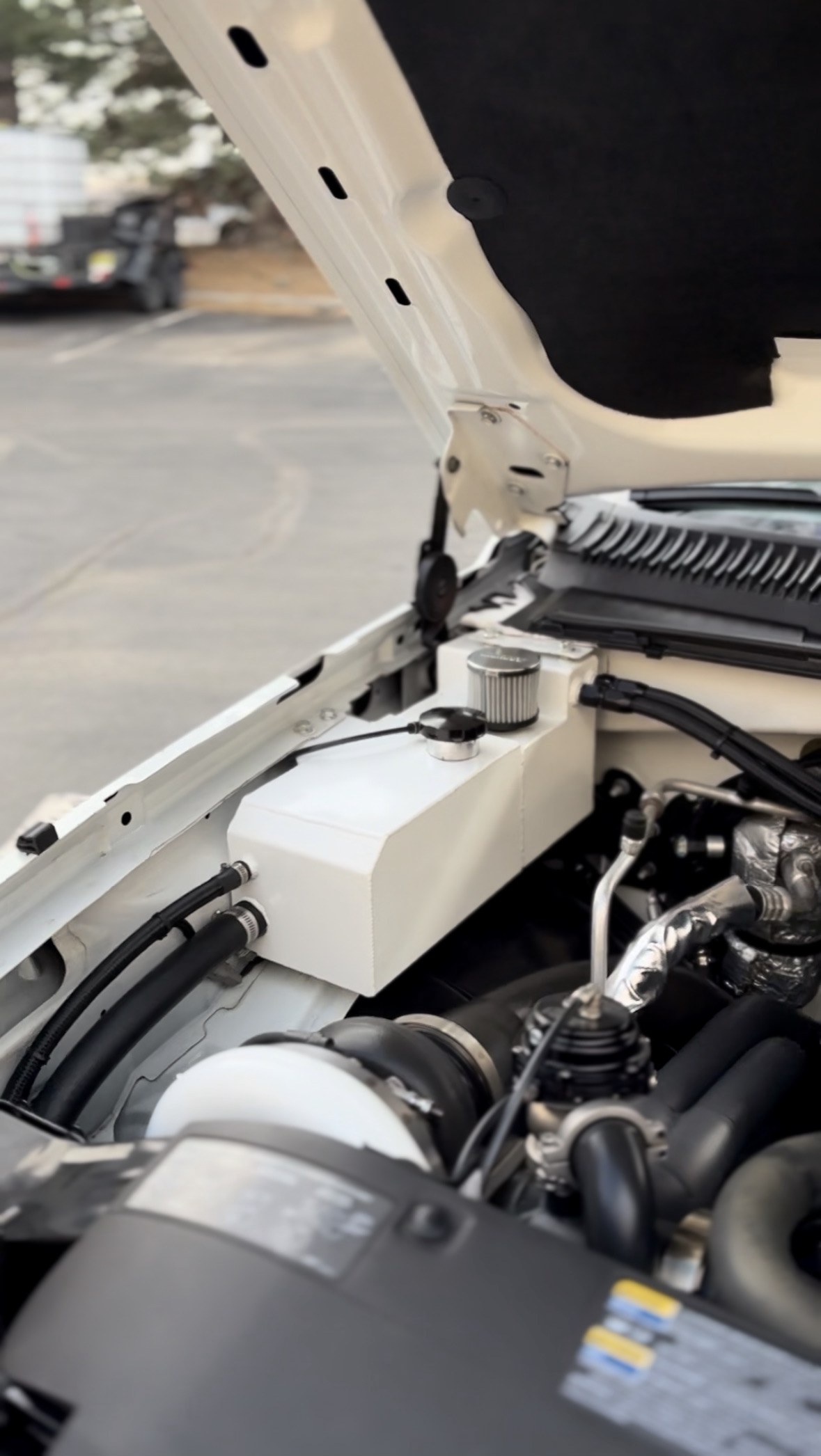 Custom white tank built to fit the corner of an engine bay