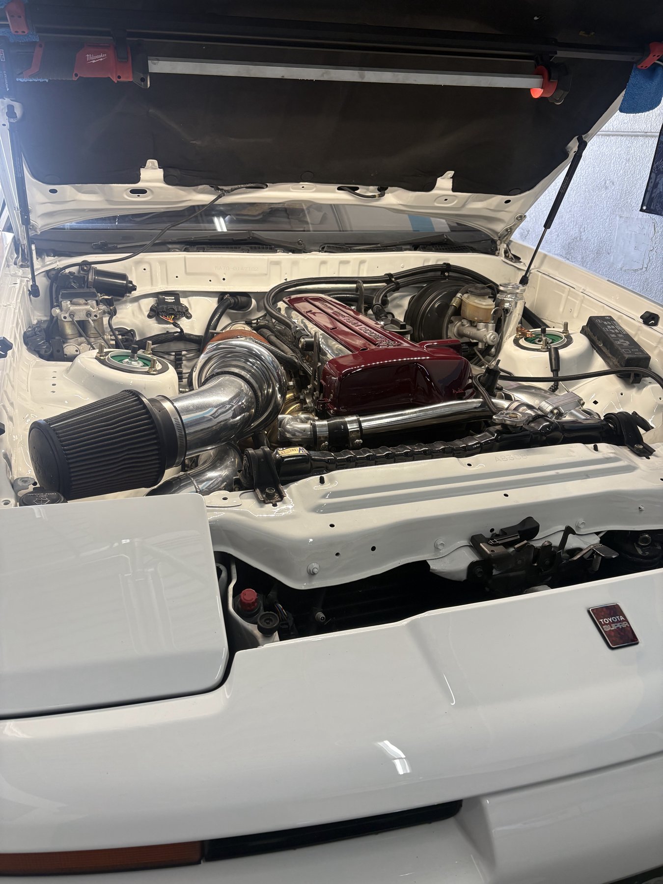 Turbocharged engine in the bay of a white Toyota Supra