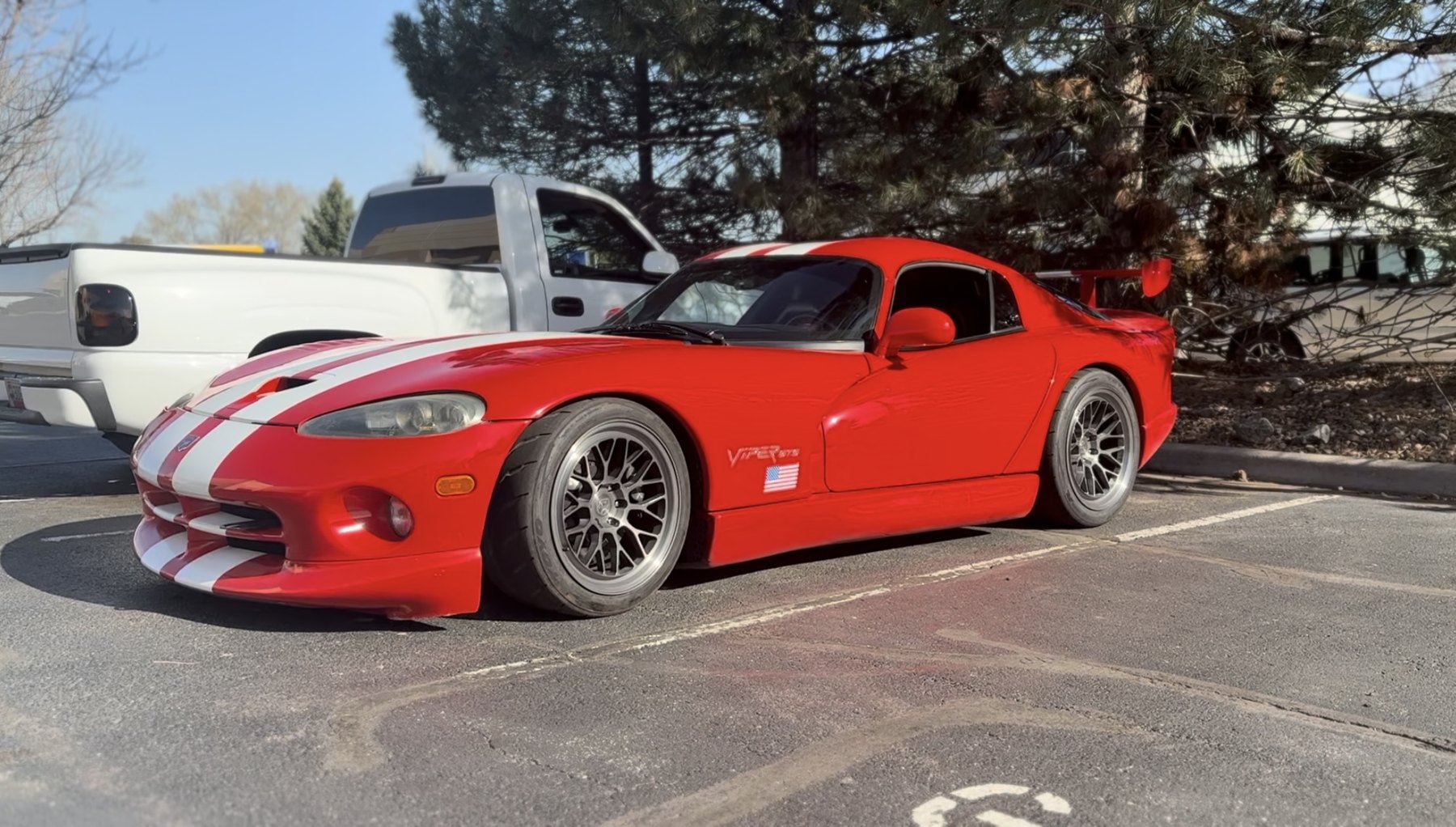 Red Viper GTS with white stripes parked in a lot