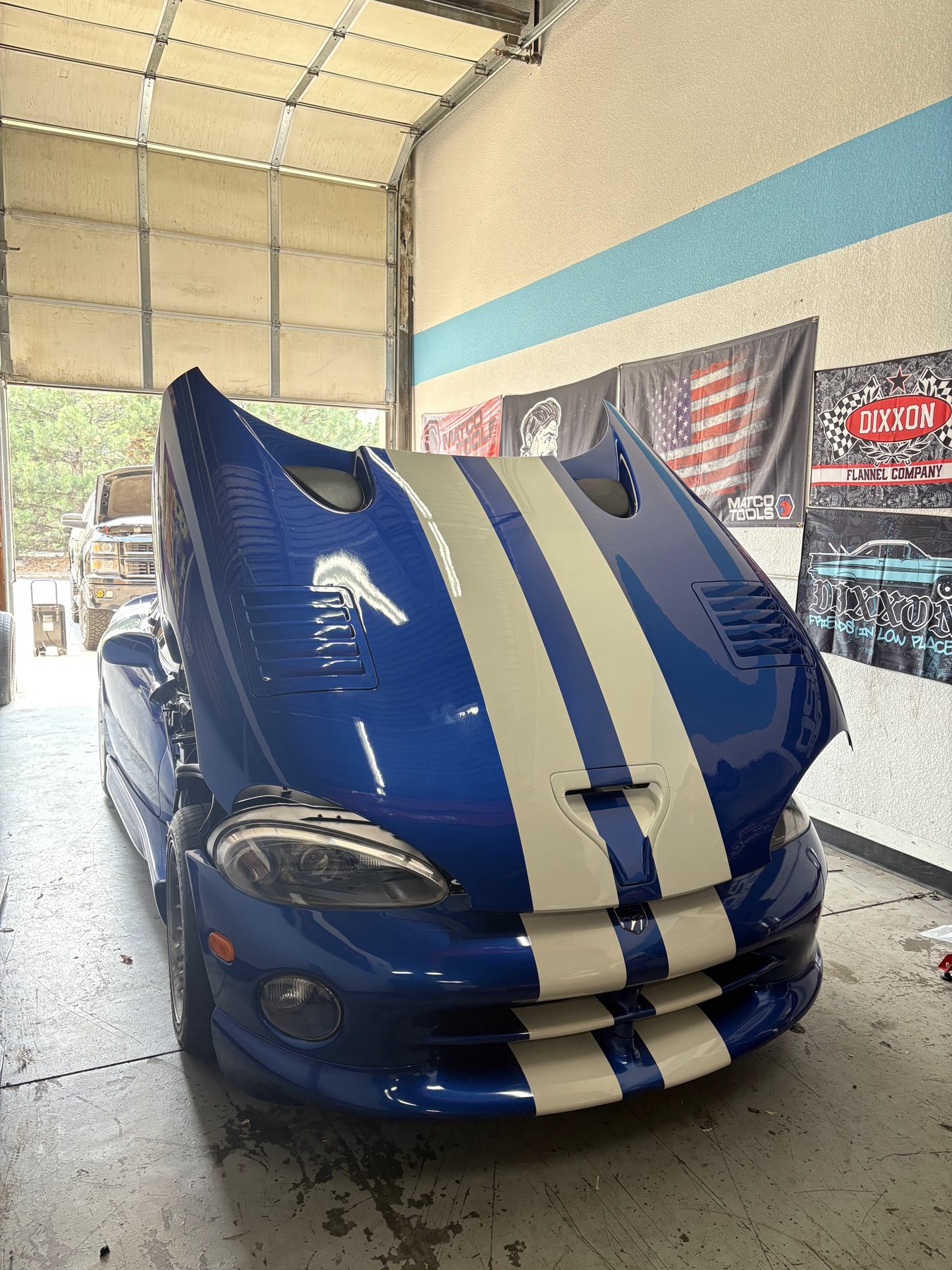 Blue Viper with white stripes in the shop with its hood open