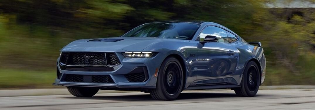 Blue 2024 Ford Mustang driving on a road